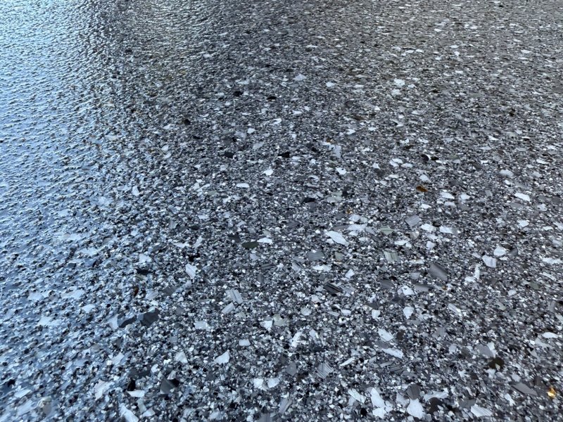 Close up of dark grey glossy flake epoxy floor coating by Premium Epoxy Flooring