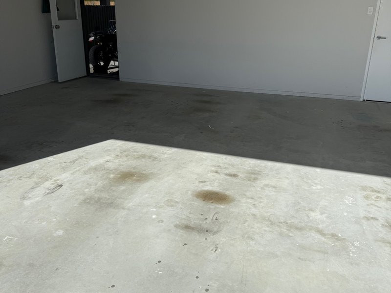 Garage floor before epoxy coating — stained bare concrete