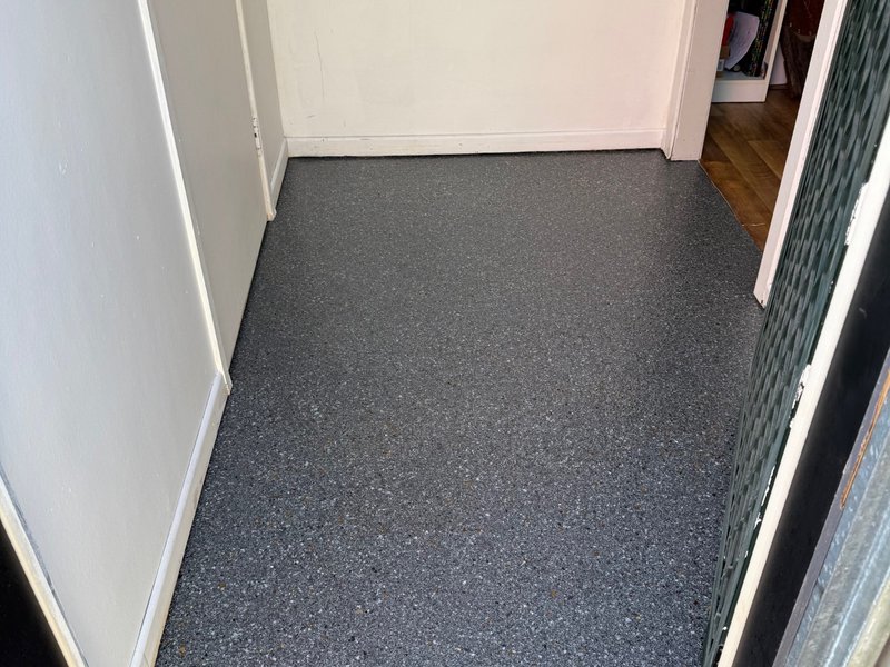 Laundry entry epoxy floor coating completed — dark grey flake system
