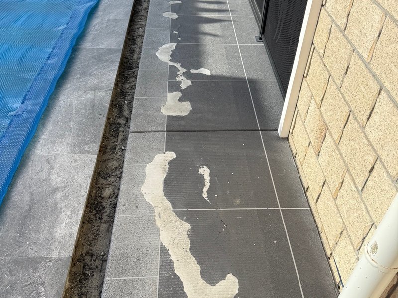 Pool surround tiles before epoxy coating — peeling and damaged surface